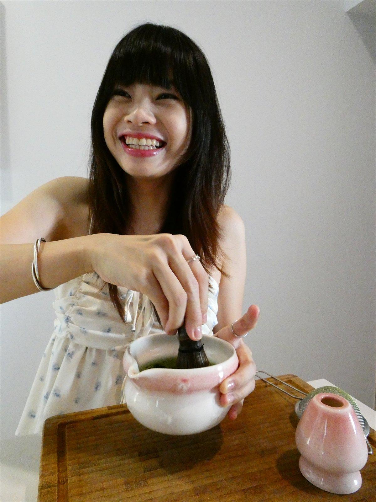 Whisking a bowl of matcha, mid-laugh